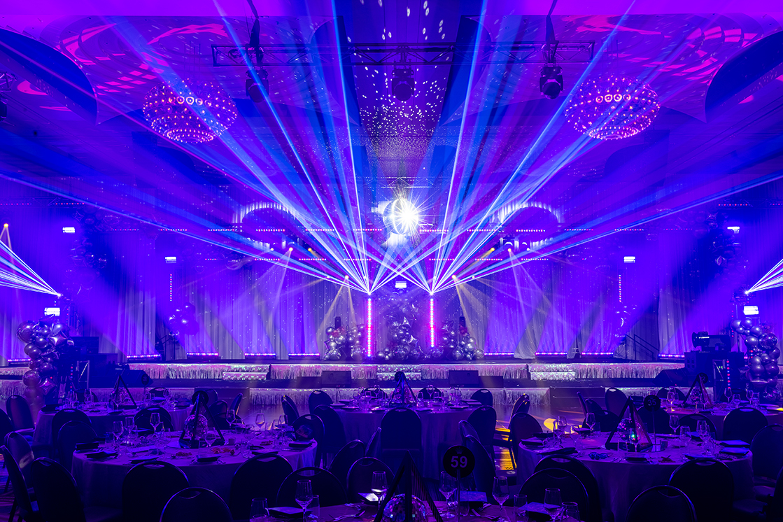 A room with tables and chairs, purple lights, and stylish decor—perfectly set up by a leading event company Melbourne for unforgettable gatherings.