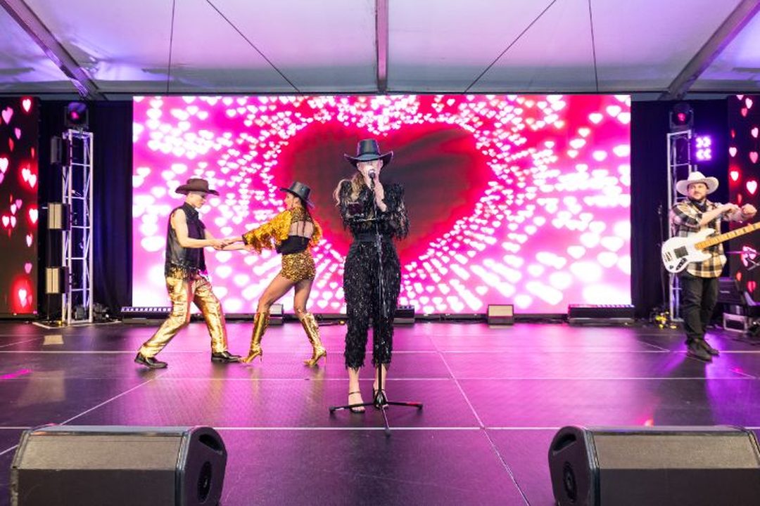 Corporate event photography showing AIA branded outback-themed entertainment, stage performances, décor details and audience activities at an awards event - Encore Event Technologies