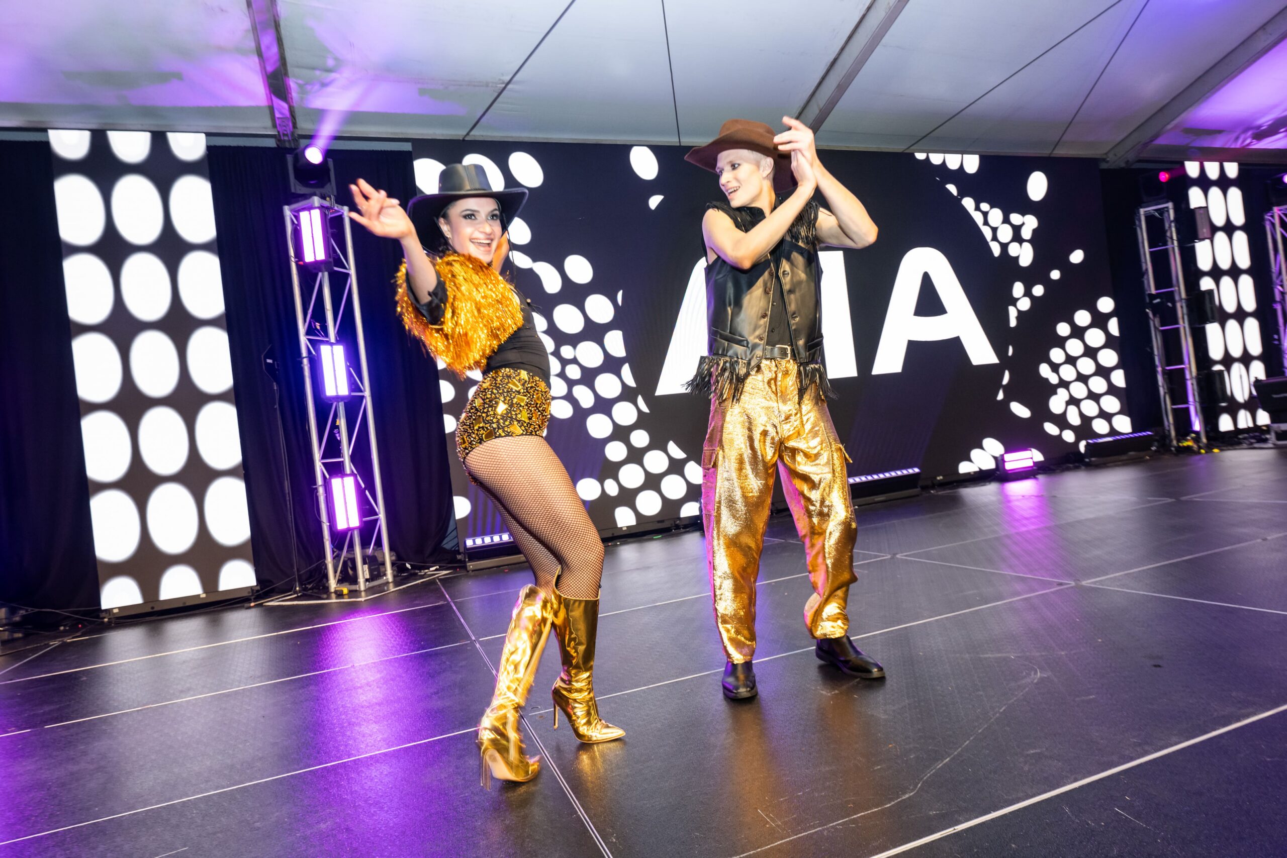 Dance duo performing choreographed routine on AIA branded event stage - Encore Event Technologies
