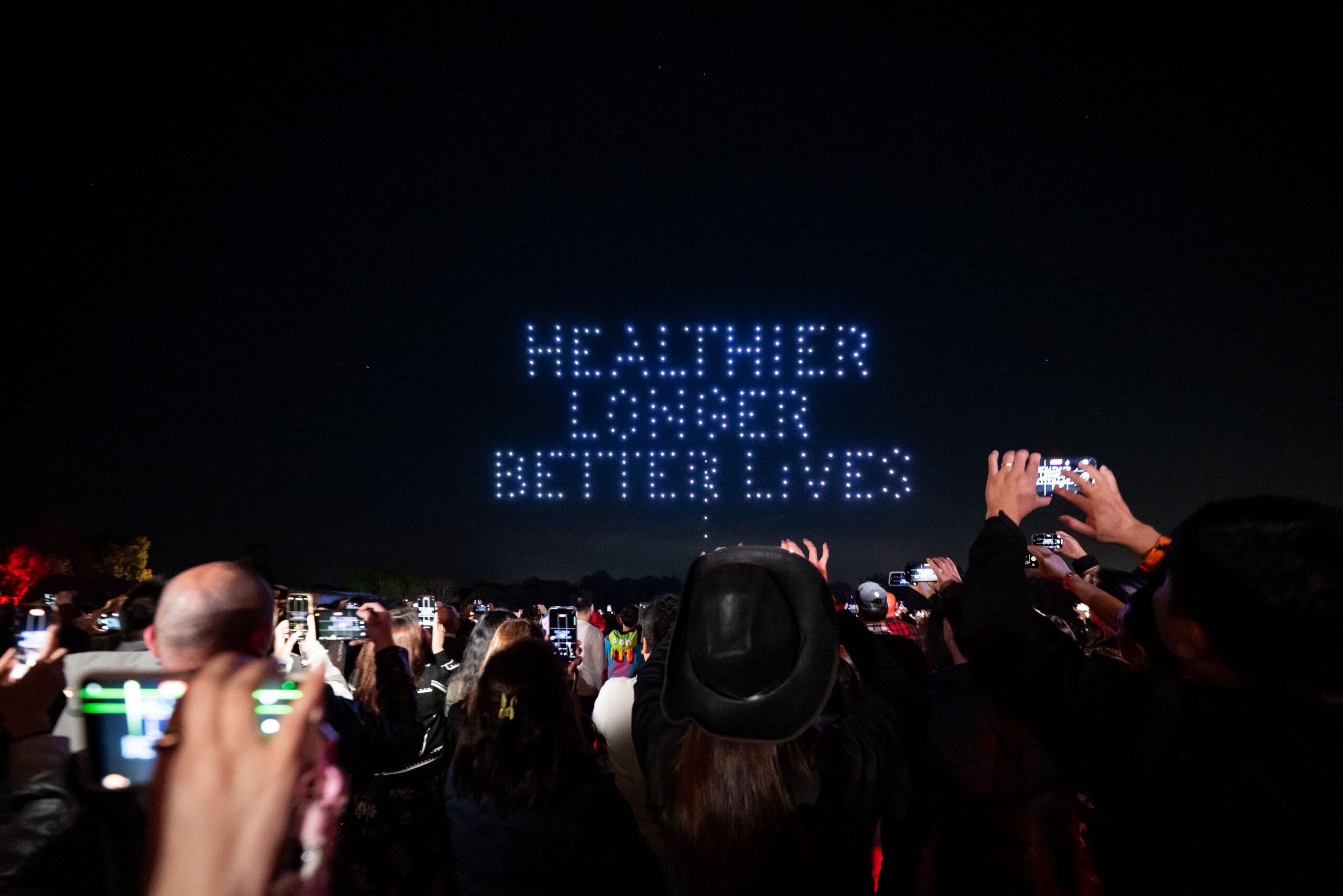 Drone light display spelling Healthier Longer Better Lives above audience - Encore Event Technologies