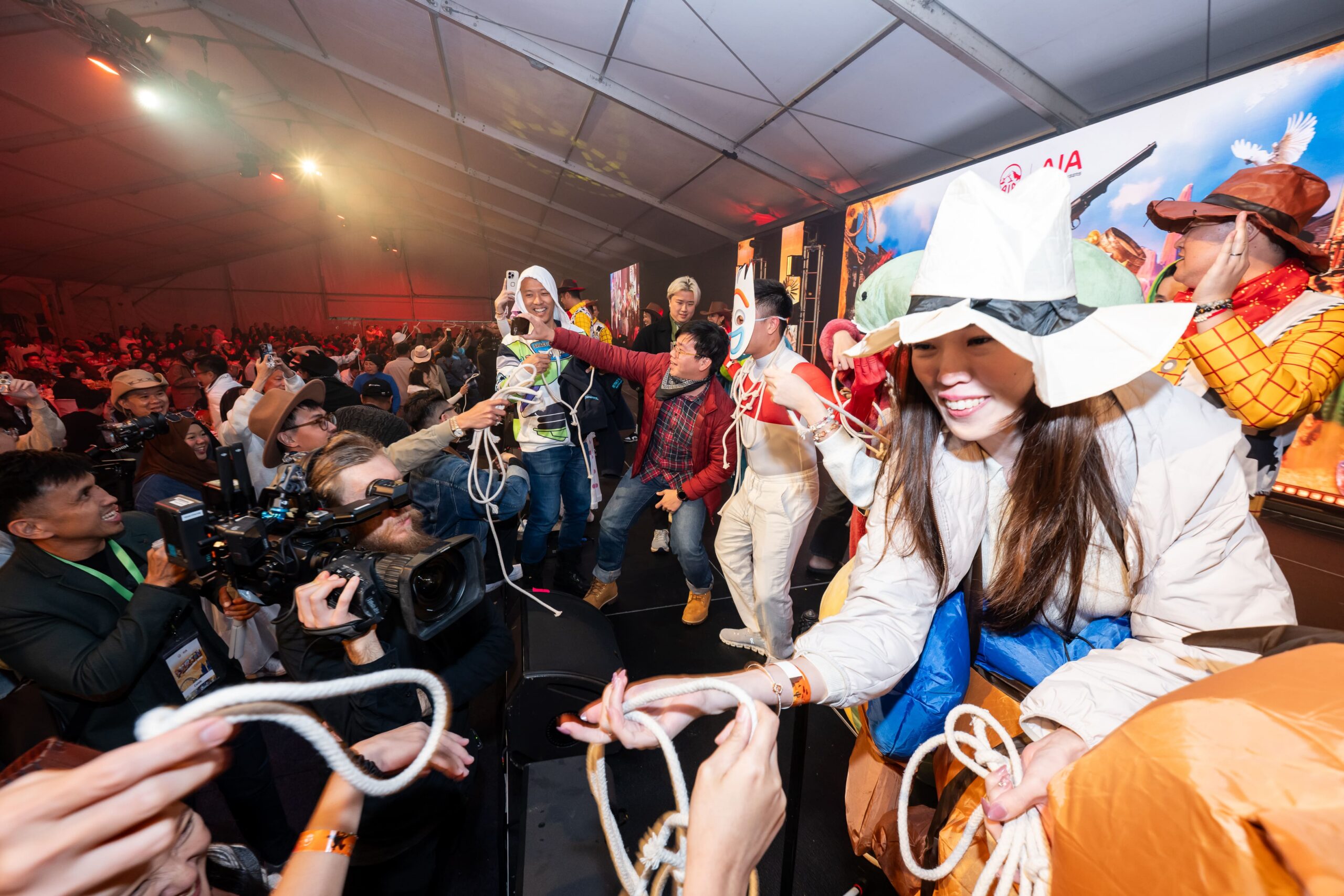 Interactive stage moment with performers engaging audience members in western themed costumes - Encore Event Technologies