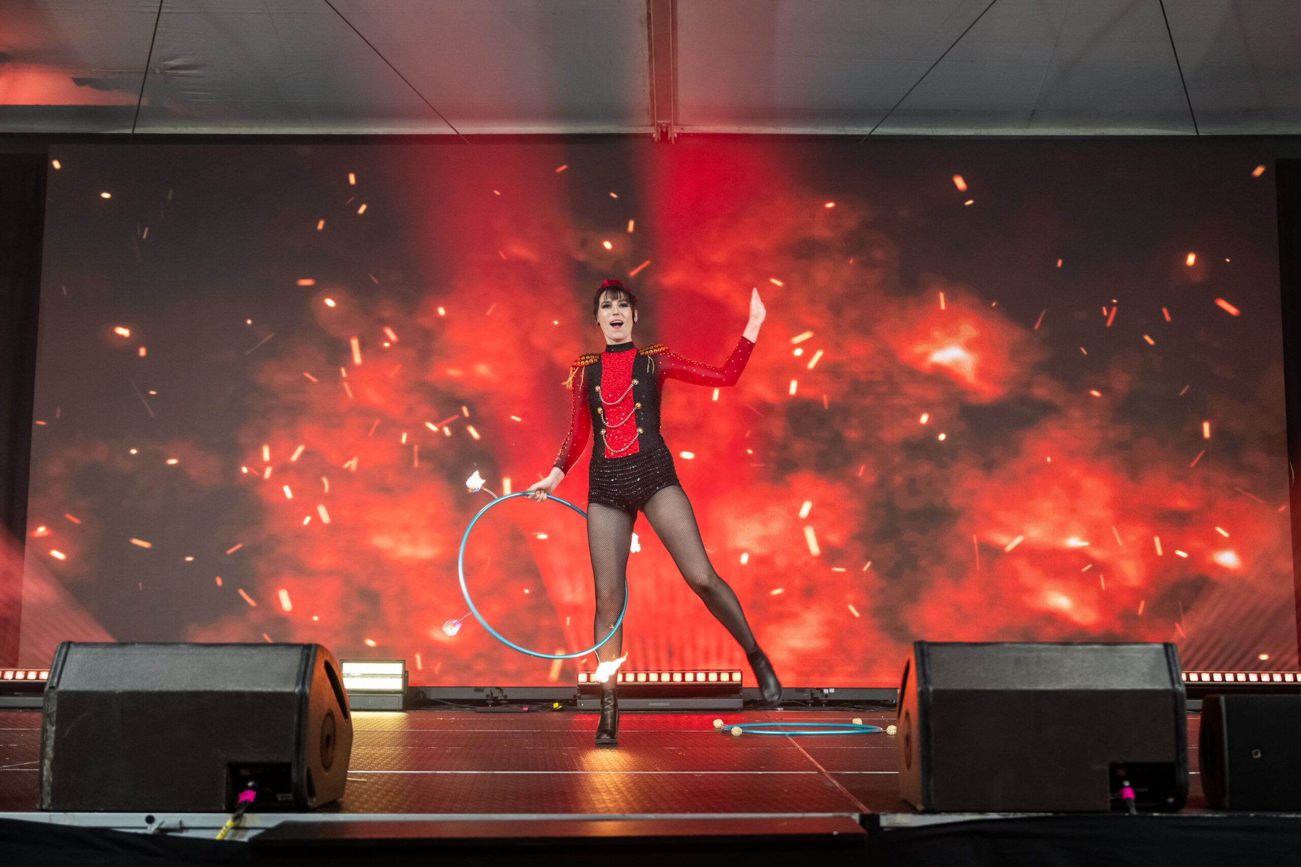 Solo stage performance featuring hula hoop act with dramatic LED fire effect backdrop - Encore Event Technologies
