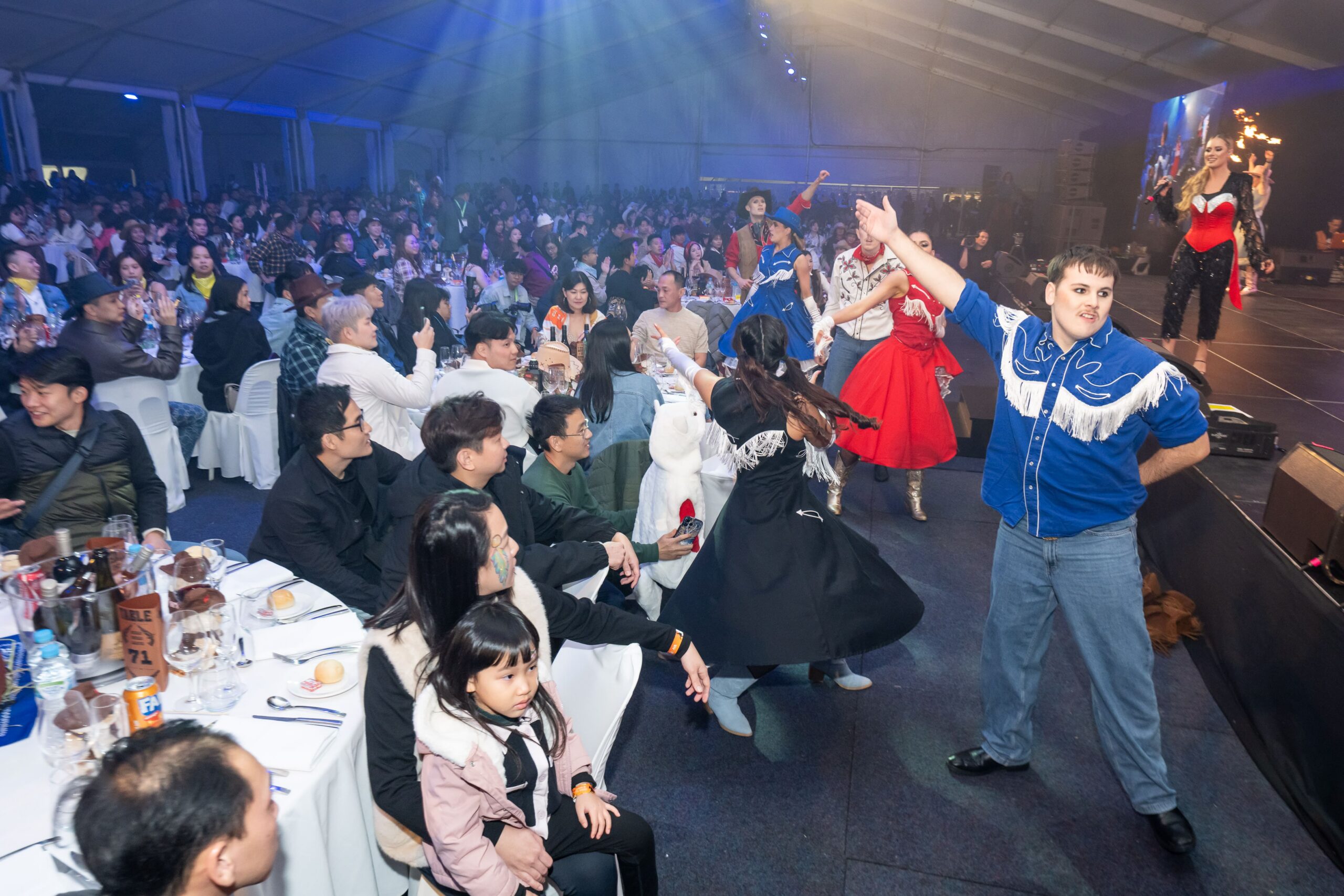 Audience participation moment with dancers engaging guests during live western themed performance - Encore Event Technologies