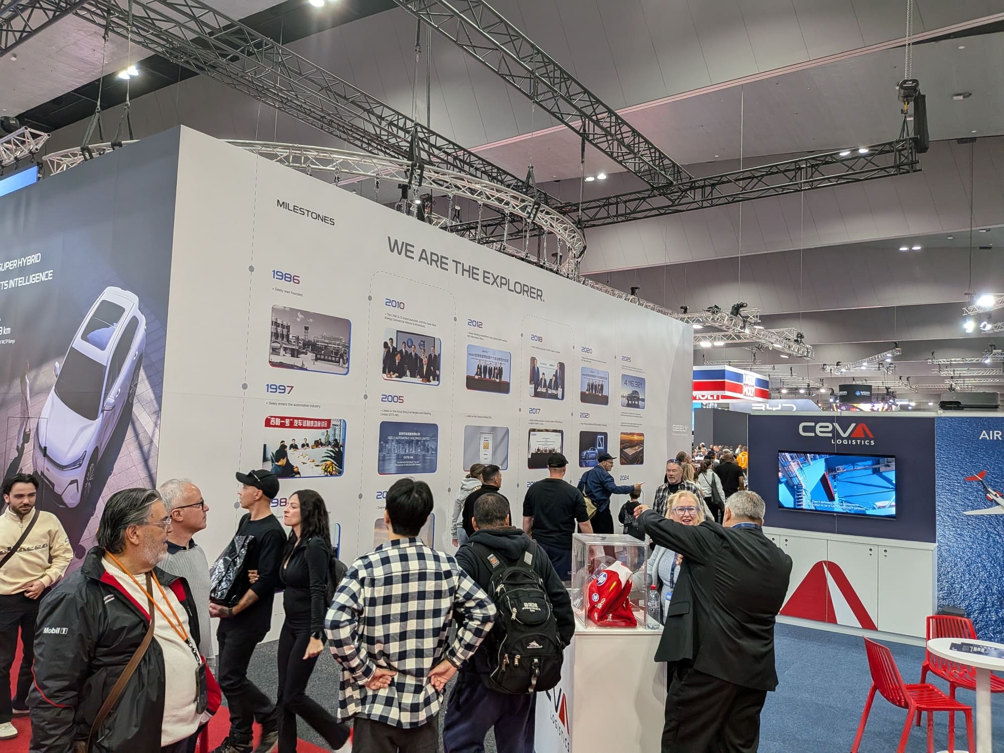 Crowded Geely exhibition stand with milestone timeline wall and attendees engaging with displays - Encore Event Technologies