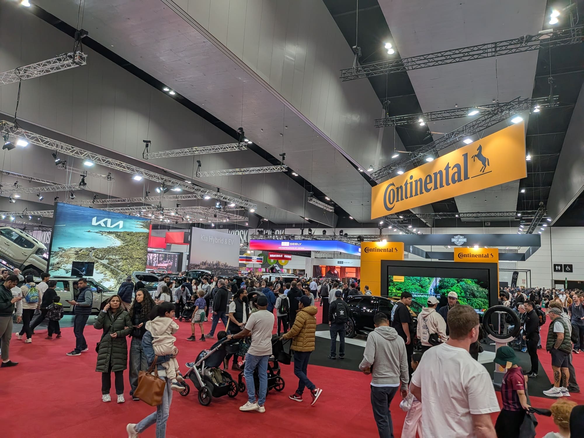 Wide exhibition hall view with multiple brand booths including Continental and visitors throughout space - Encore Event Technologies