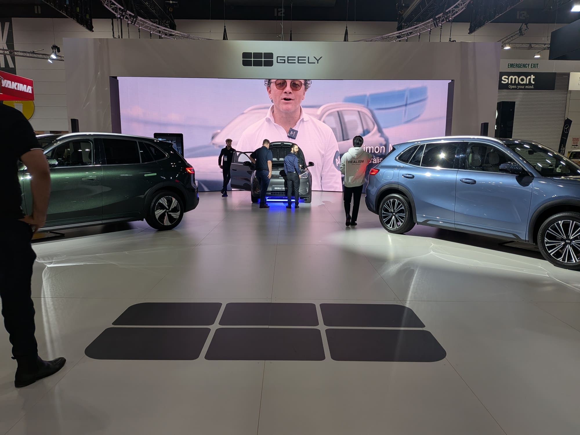 Geely stand with large LED screen backdrop and vehicles positioned for showcase - Encore Event Technologies