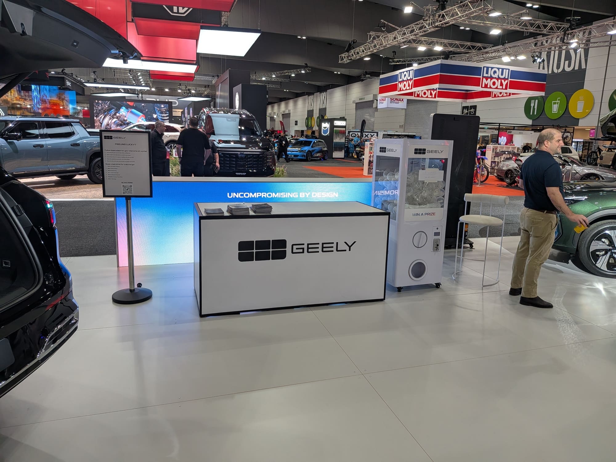 Geely reception counter with branded signage and exhibition lighting in show environment - Encore Event Technologies