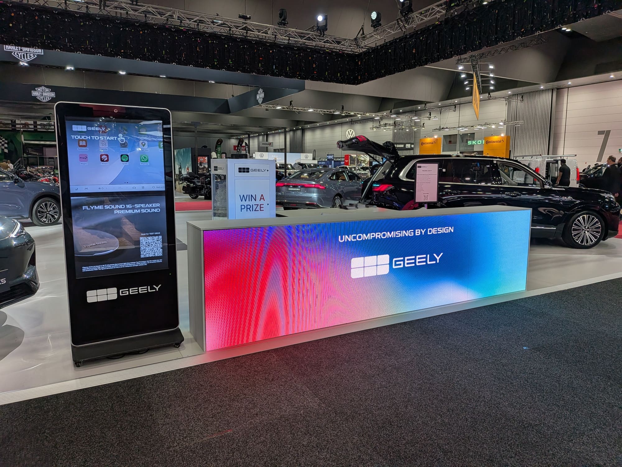 Geely activation counter with digital kiosk and promotional signage in motor show setting - Encore Event Technologies