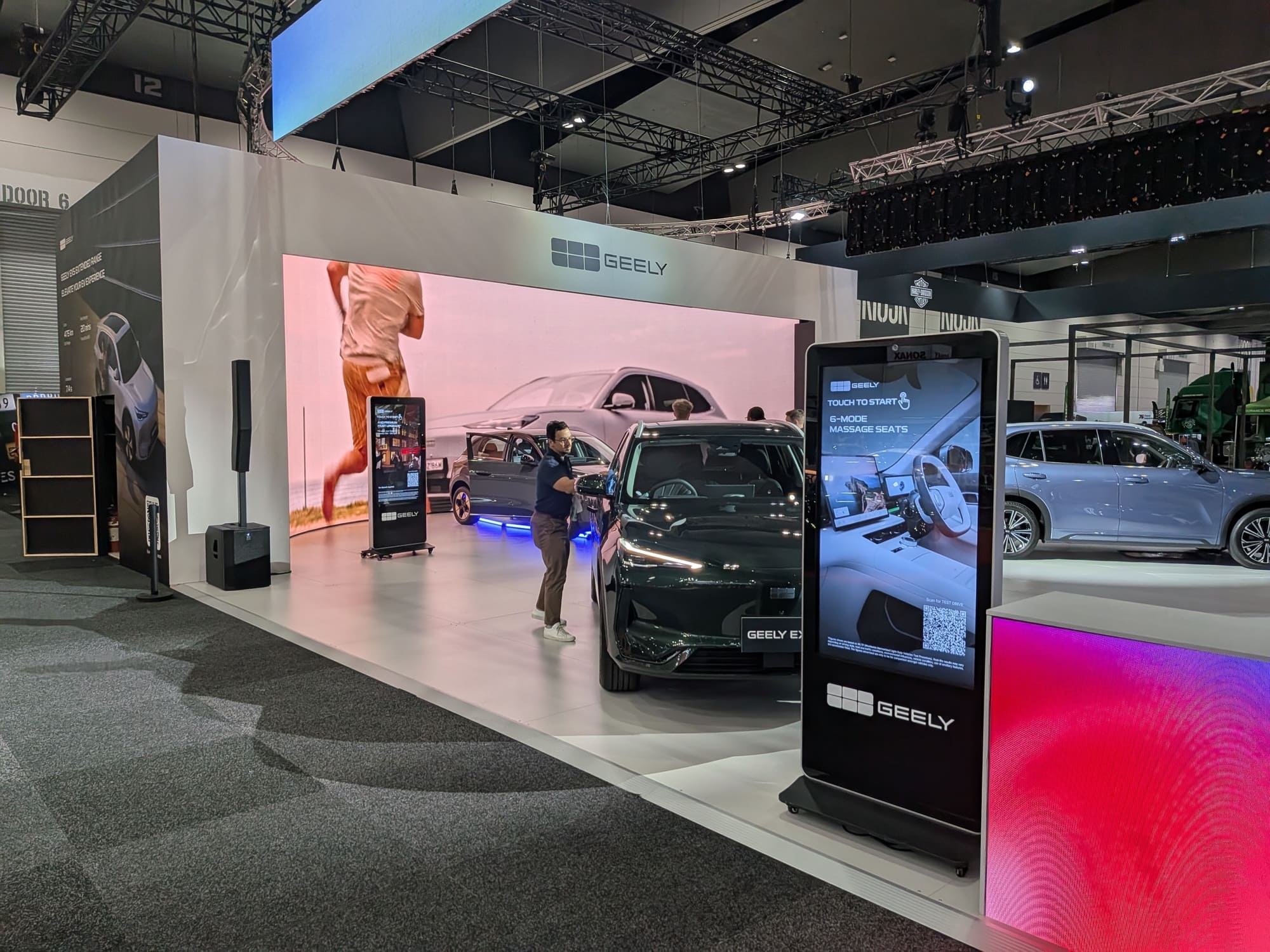 Geely booth with large LED screen backdrop and vehicle positioned for presentation - Encore Event Technologies