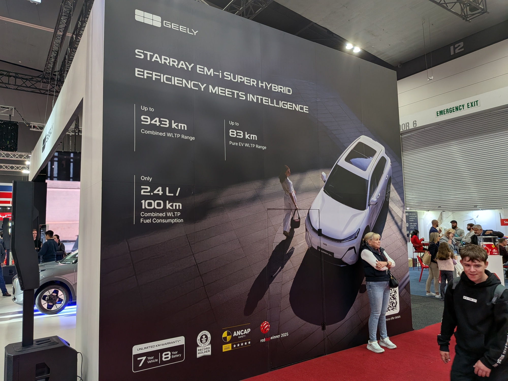 Large informational display wall highlighting Geely vehicle performance specifications and hybrid technology messaging - Encore Event Technologies
