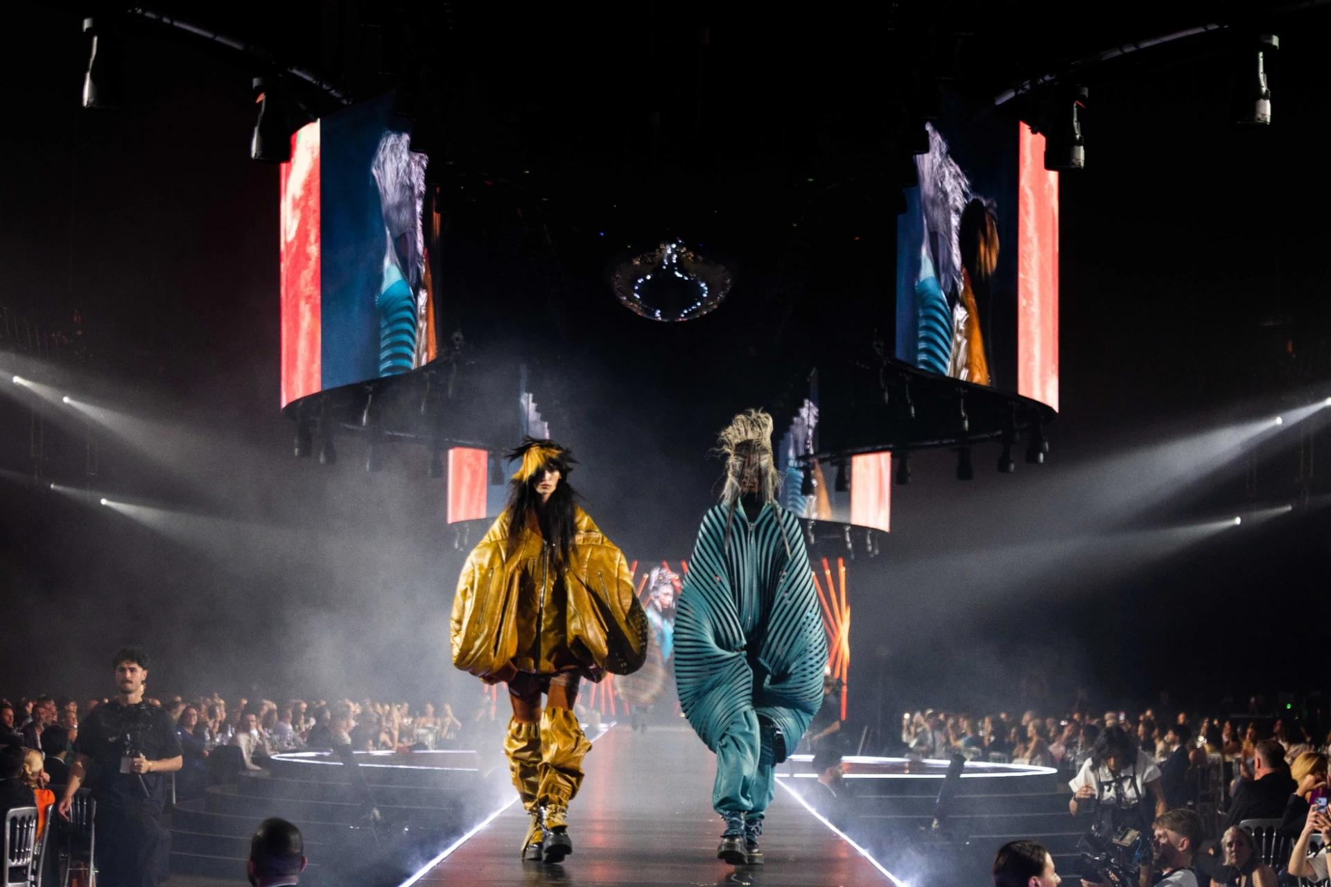 Runway performers surrounded by blue vertical lighting and large-scale digital screens - Encore Event Technologies