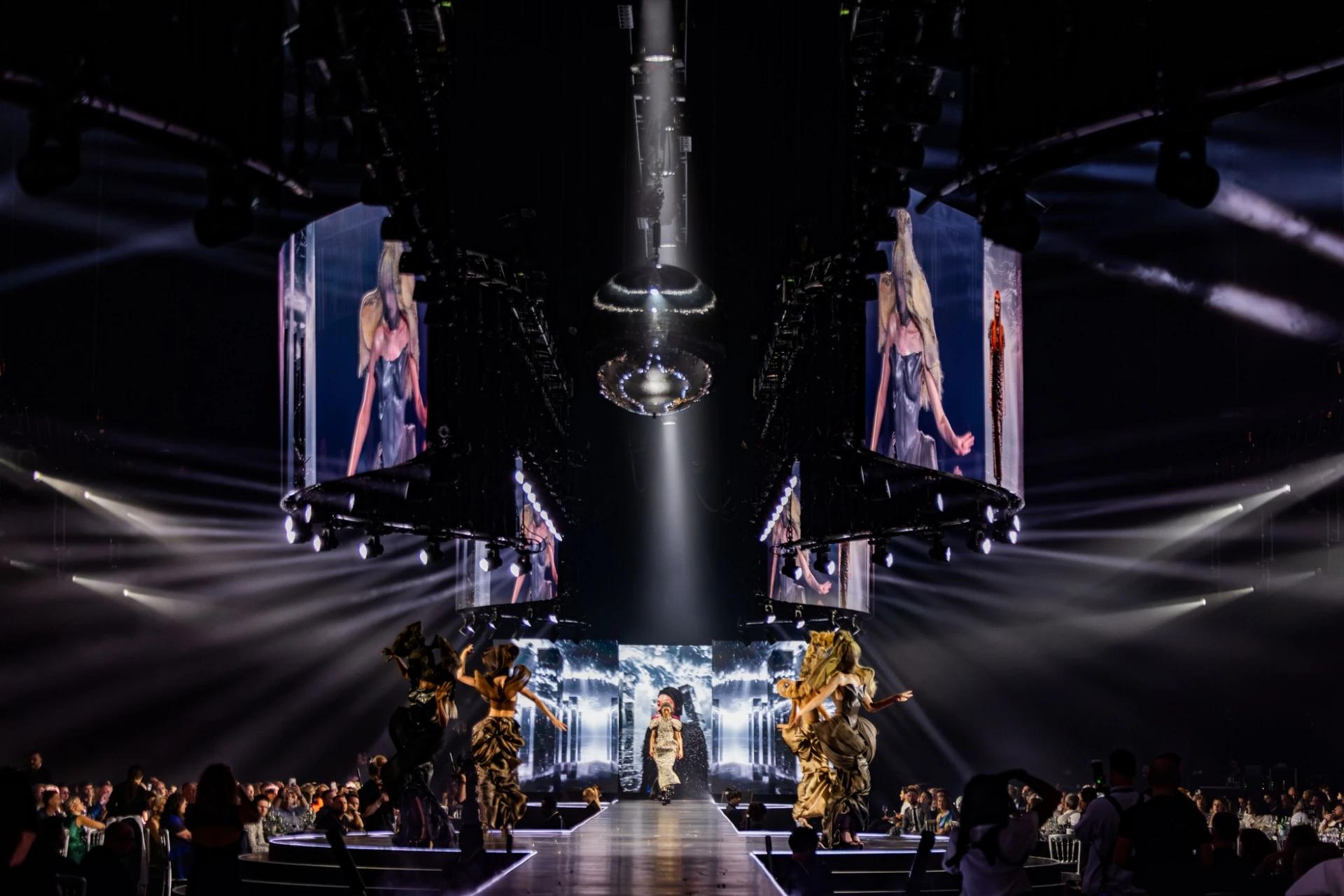 L'Oréal Colour Trophy event with presenter on an illuminated runway and large overhead screens - Encore Event Technologies