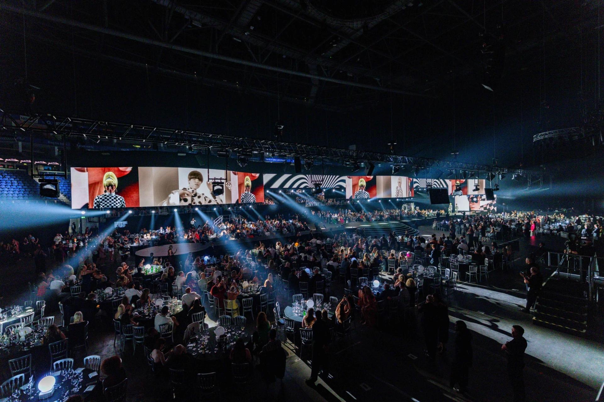 L'Oréal Colour Trophy event with presenter on an illuminated runway and large overhead screens - Encore Event Technologies