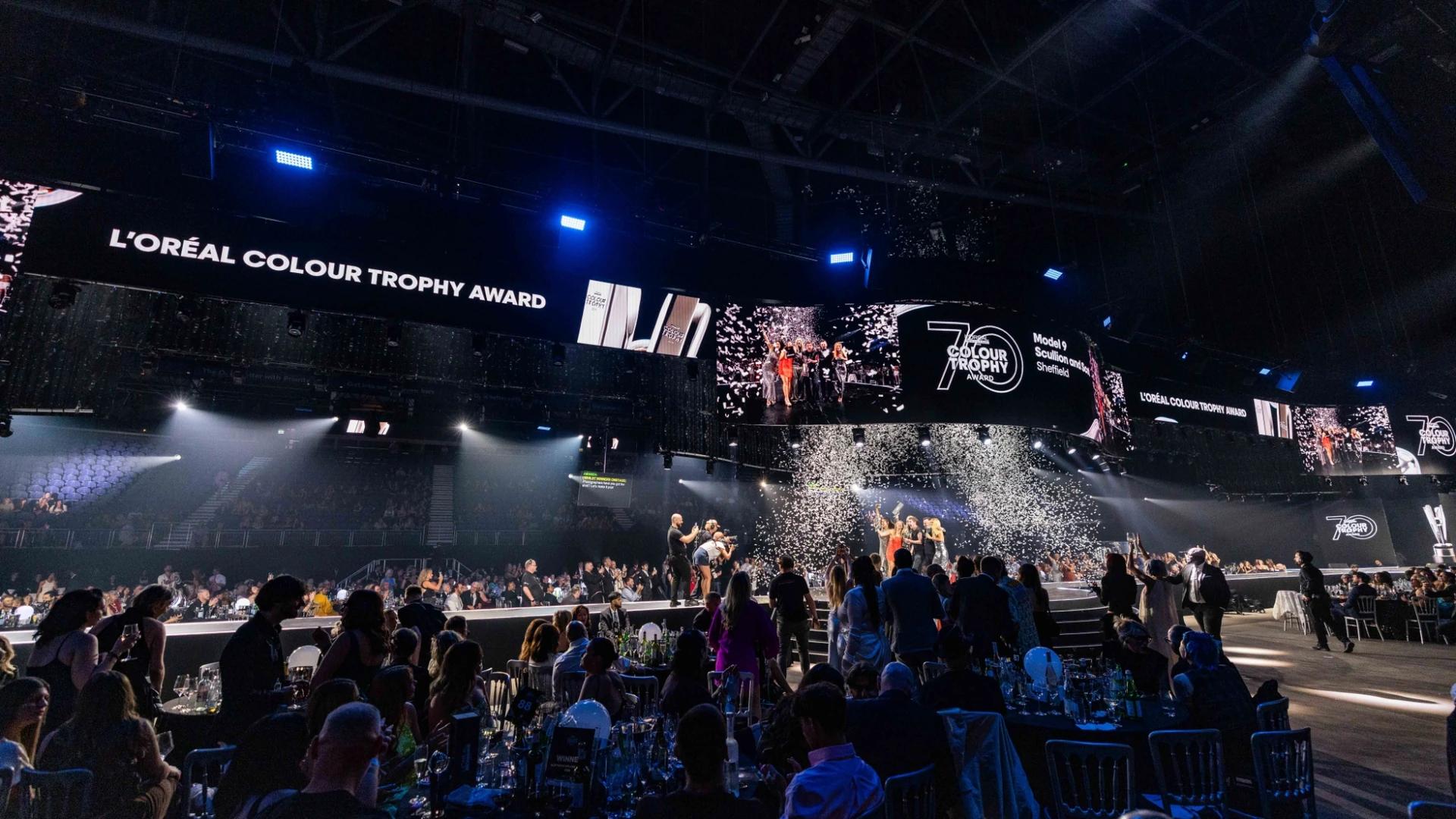 L'Oréal Colour Trophy event with presenter on an illuminated runway and large overhead screens - Encore Event Technologies