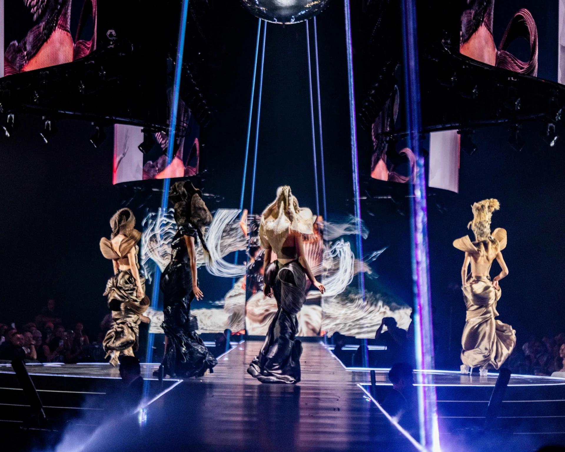 Large curved LED display above a red illuminated runway at an arena event - Encore Event Technologies