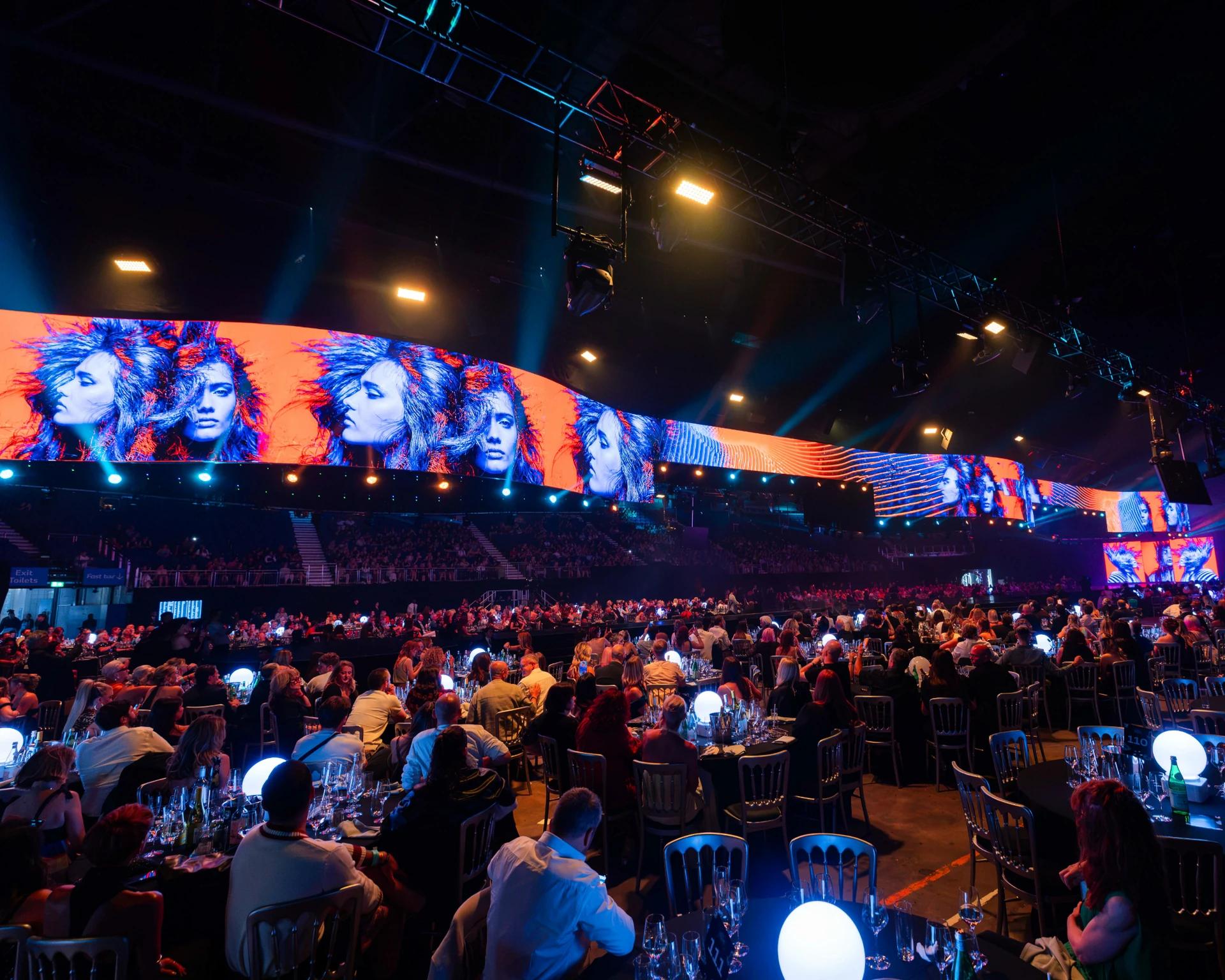 Large-scale arena production featuring an illuminated runway and expansive digital screens - Encore Event Technologies