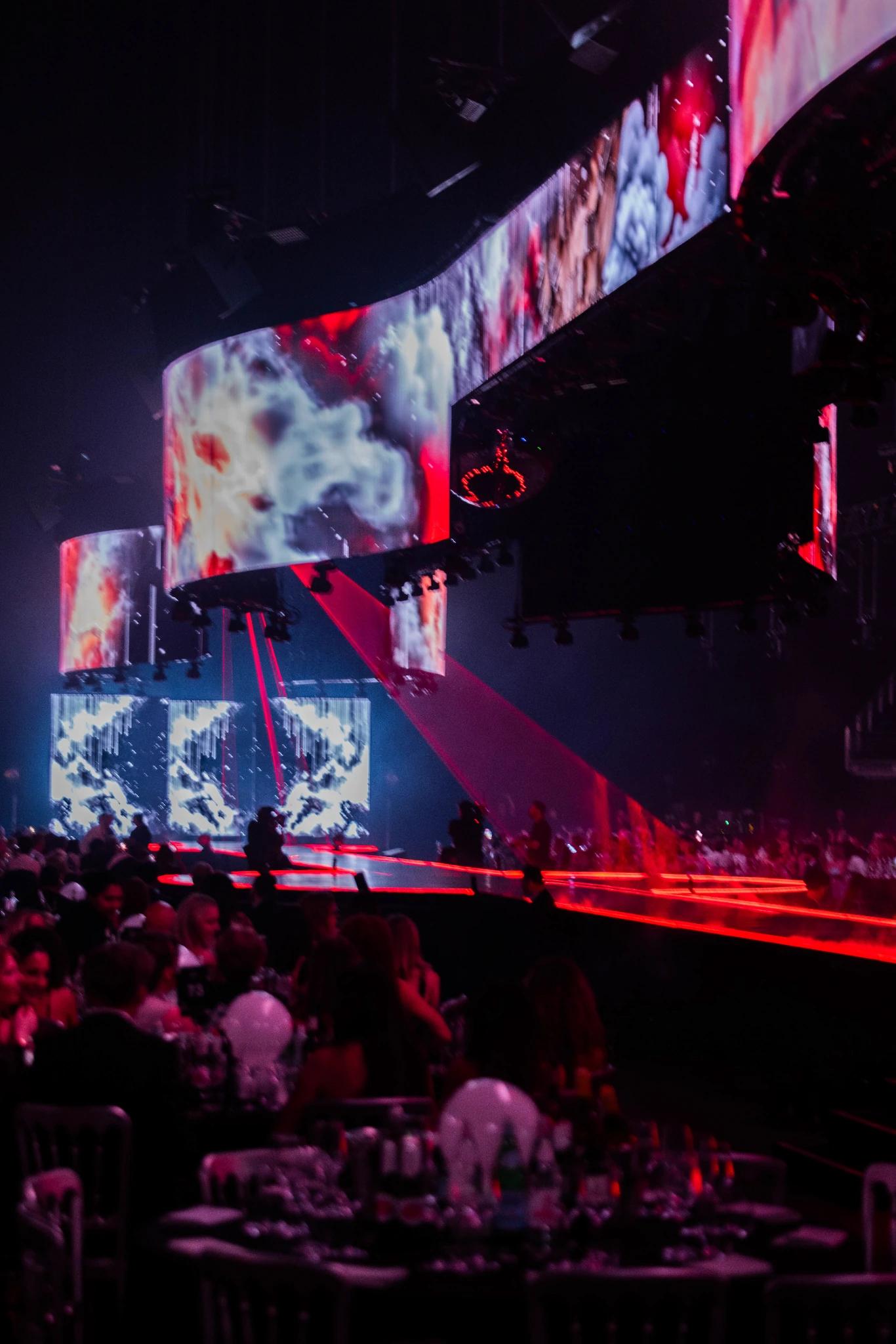 Dramatic runway production framed by large digital screens and theatrical lighting - Encore Event Technologies